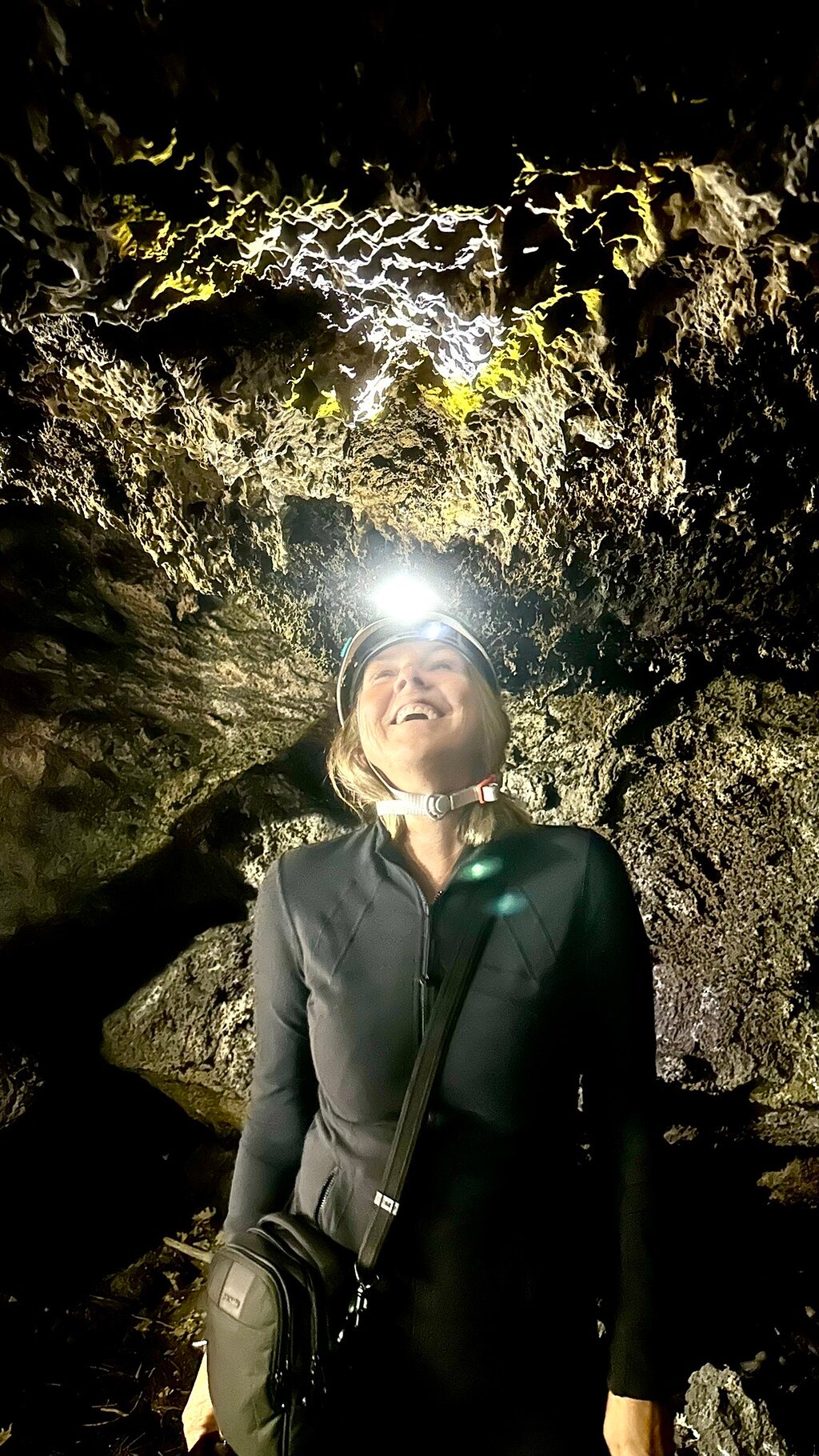 Hiker with helmet and torch inside the Robbers' Cave
